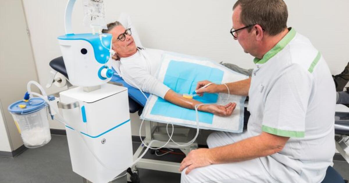 Een wondzorgspecialist van Ziekenhuis aan de Stroom verwijdert vuil uit een wonde met de Debitrom+. Het toestel vervangt het scalpel waarmee normaliter weefsel wordt weggesneden. (Foto: ZAS / Dirk Kerstens)